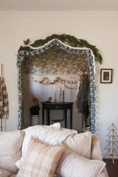 a living room filled with furniture and a fire place covered in christmas garlands on the mantle