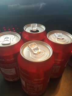 six red soda cans sitting on top of a table