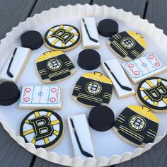 decorated cookies in the shape of hockey jerseys on a cake platter with puckers and sticks
