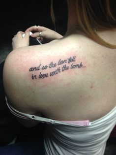 a woman with a tattoo on her back saying, and so the lion fell in love with the lambs