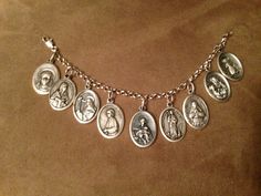 End of year project idea - make a bracelet for each girl using medals from every saint that they studied that year or the patron saint from each of the girls in the group.  Could add beads on head pins to add color. Catholic Religious Beads, Catholic Religious Jewelry Ideas, Catholic Prayer Beads Jewelry, Catholic Jewelry Scaperal, How To Wear Prayer Medals, Catholic Medals And Rosary Supplies, Catholic Saint Charm, Vintage Catholic Jewelry Ideas, Spiritual Jewelry The Catholic Company