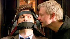 two men with blindfolds on their faces are looking at each other