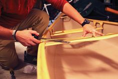 a man is working on a boat in the water and it's being sanded