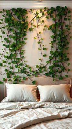 a bed with white pillows and green plants on the wall above it's headboard
