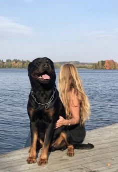 a woman sitting on a dock with her dog