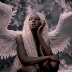 a woman with white hair and angel wings sitting in front of her face, looking at the camera