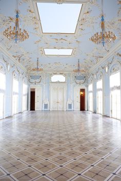 an empty ballroom with chandeliers and blue paint on the walls is seen in this image