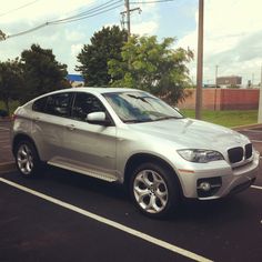a silver bmw suv parked in a parking lot