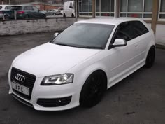 a white car parked in front of a building