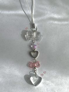 a key chain with two hearts hanging from it's side on a white cloth
