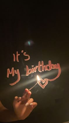 it's my birthday written on a piece of paper with a lit candle