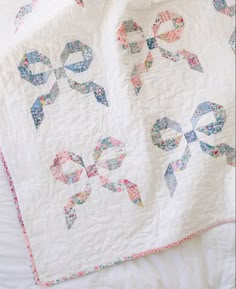a white quilt with blue and pink bows on it