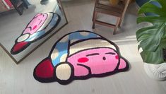 a rug with a cartoon character on it next to a mirror and potted plant