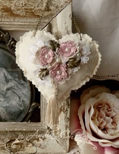 there is a heart shaped box with flowers on it next to a flower arrangement and a mirror