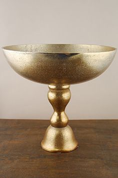 a gold bowl sitting on top of a wooden table