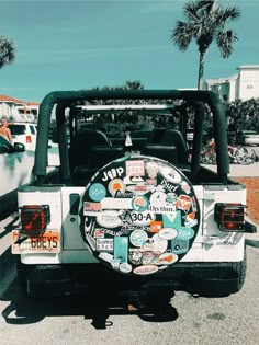 the back end of a white jeep with stickers all over it's bumper