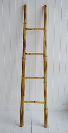 a wooden ladder leaning against a white wall