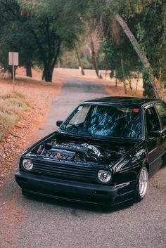 the car is parked on the side of the road with its hood up and it's engine exposed