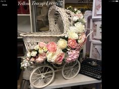 a white wicker baby carriage with flowers on it
