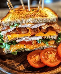 a sandwich with bacon, lettuce and tomato slices on a wooden platter