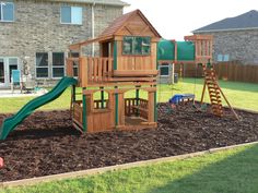 a wooden play set in the middle of a yard