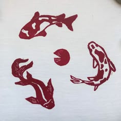 two red fish and one black fish on a white t - shirt that says koi