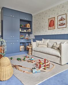 a living room with toys on the floor and furniture in front of it, including a couch