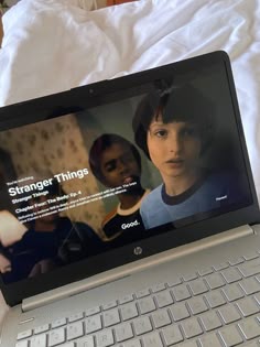 an open laptop computer sitting on top of a bed