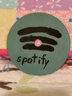 a wooden sign with the word spotify painted on it's face and handwritten lettering