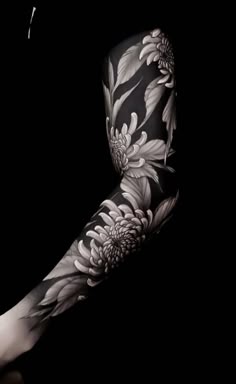 a woman's arm with black and white flowers on it