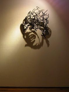 the shadow of a plant is cast on a wall by a light that has been turned on