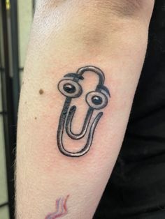 a man with a tattoo on his arm that has an image of a hook in it