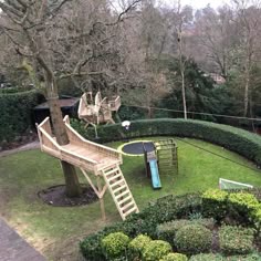an aerial view of a children's play area surrounded by hedges, trees and other greenery