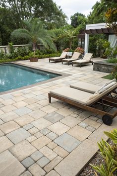 an outdoor pool with lounge chairs next to it