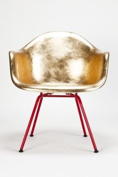 a gold chair sitting on top of a red stand