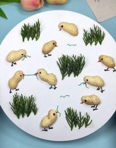 a white plate topped with lots of small birds on top of green plants and grass