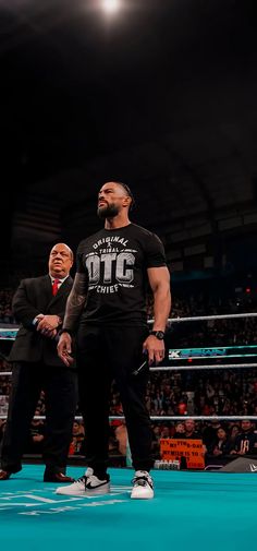 two men standing next to each other in a wrestling ring