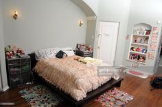 a bed room with a neatly made bed and lots of clutter on the floor