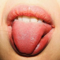 a woman's tongue is covered in pink powder and has it's tongue sticking out