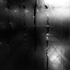 black and white photograph of rain drops on glass