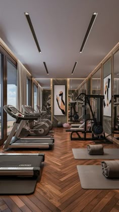 there are many treadmills in the gym with windows overlooking the water and mountains