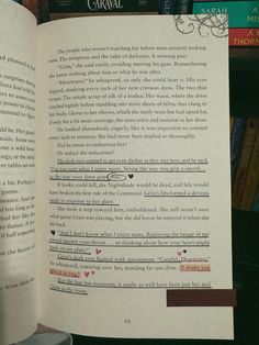 an open book sitting on top of a table next to a cup and bookshelf