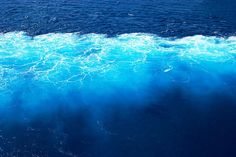 the water is blue and foamy as seen from a boat on the ocean floor
