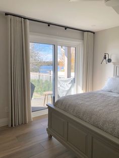a bedroom with a large bed and sliding glass doors leading to an outside deck area