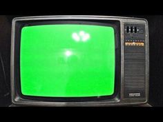 an old television with green screen in the dark