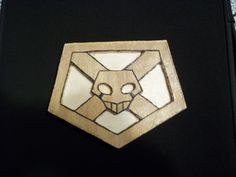a wooden badge with an animal's face in the shape of a hexagon