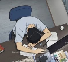 a man sitting at a desk with his head down