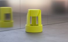 two yellow stools sitting next to each other in front of a wall with mirrors
