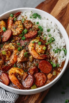 a white bowl filled with shrimp, sausage and rice