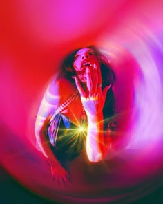 a woman with her hands on her face in front of a red and purple background